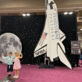 Children pose for pictures in front of a space-themed backdrop. (Miranda Cazares/Reporting Texas TV)
